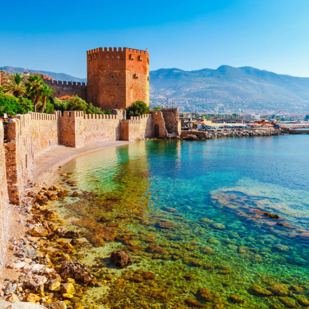 Kizil Kule tower in Alanya peninsula, Antalya district, Turkey, Asia. Famous tourist destination with high mountains. Part of ancient old Castle. Summer bright day